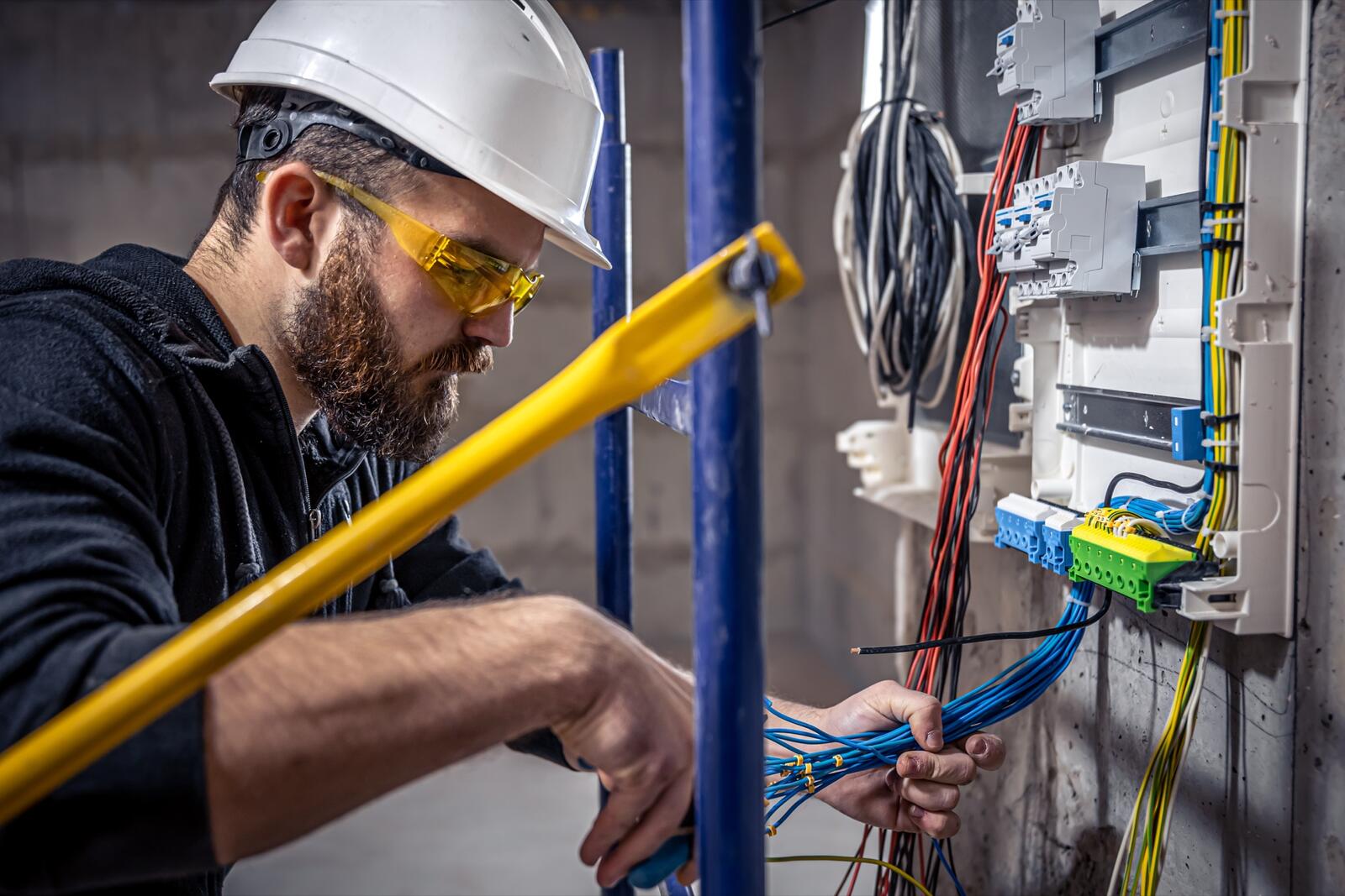 Eletricista certificado da EletroSantosPro a trabalhar num quadro elétrico
